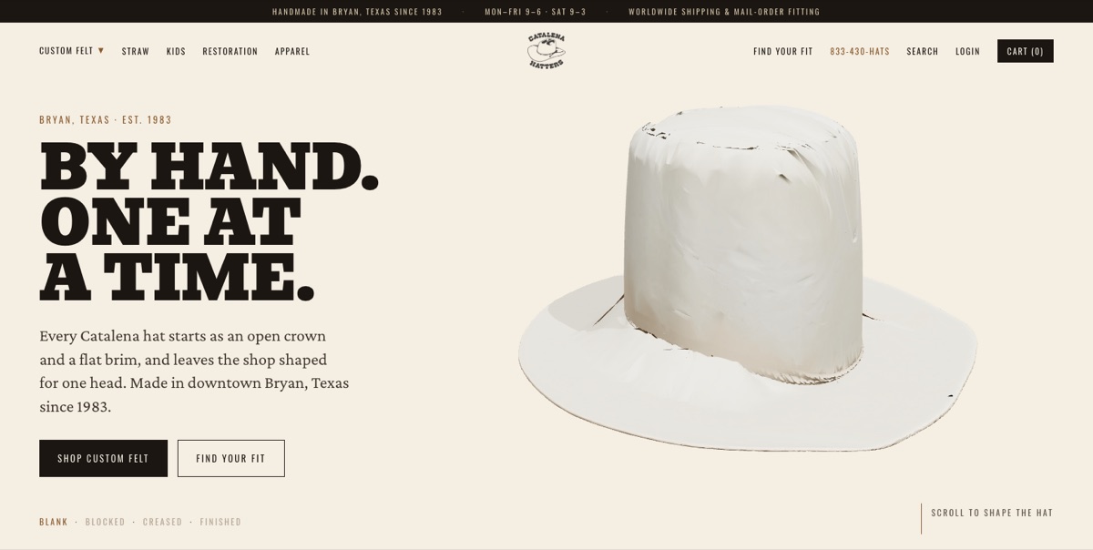 Version 2 on desktop: a cream page with the headline By hand. One at a time. set in a heavy slab serif, one paragraph about the shop, a Shop custom felt button and a Find your fit button, and a three-dimensional bone felt hat with an open crown and a flat brim on the right. A track along the bottom reads blank, blocked, creased, finished. Opens in a new tab.