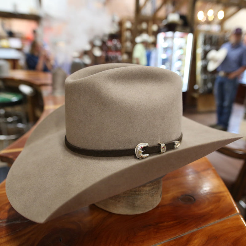 Silverbelly felt hat with a leather band and silver buckle on a cedar counter