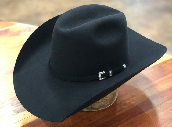 Black Top Hand felt hat with a silver-buckle band on a wooden counter