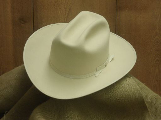 Bone LBJ felt hat with a tall open crown on burlap